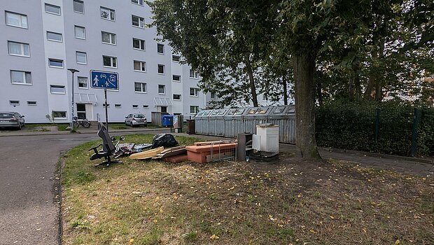 Grünfläche mit Wohnblock im Hintergund.