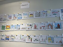 Viele bunte kleine Bilder an einer Wand.