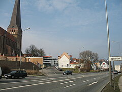 Blick auf eine befahrene Straße mit Petrikirche im Hintergund.