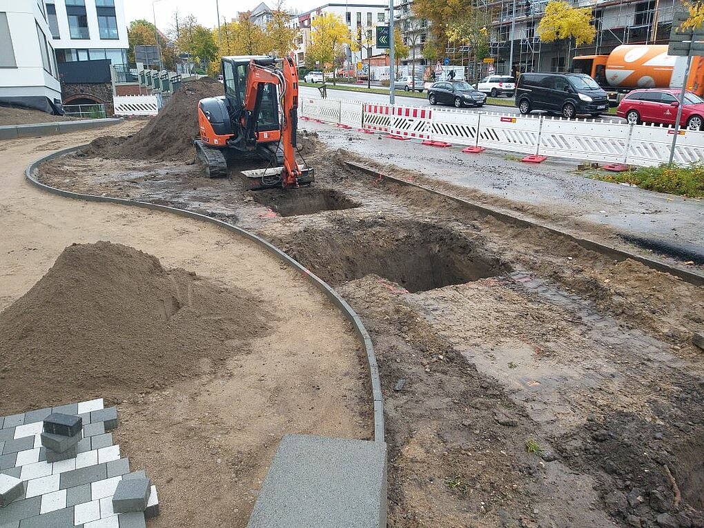 Abgesperrte Buastelle mit Baufahrzeug.