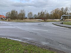 Straßenkreuzung mit Schlaglöchern.