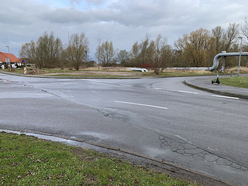 Straßenkreuzung mit Schlaglöchern.