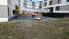 Blick auf eine Baustelle umgeben von Gebäuden.