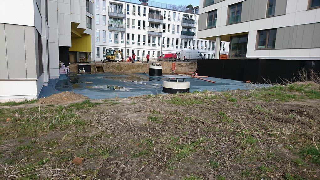 Blick auf eine Baustelle umgeben von Gebäuden.