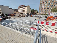 Baustelle mit Absperrungen und Baugeräten.