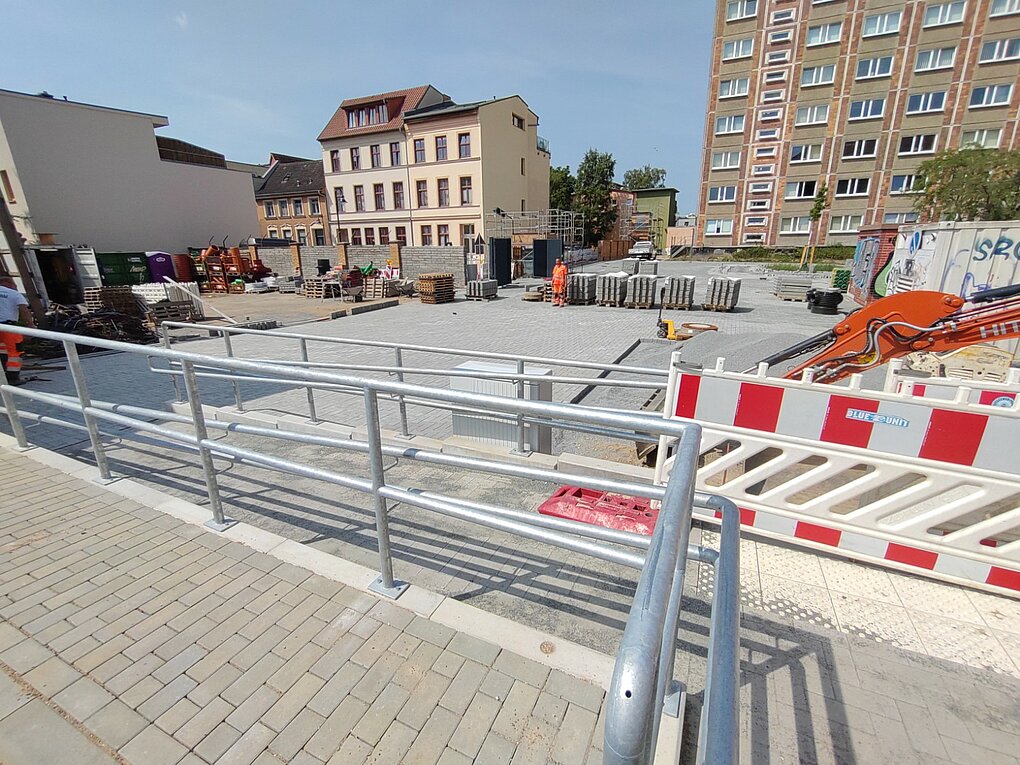 Baustelle mit Absperrungen und Baugeräten.