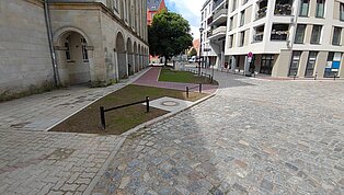 Gepflasterten Platz zwischen Wohngebäuden.
