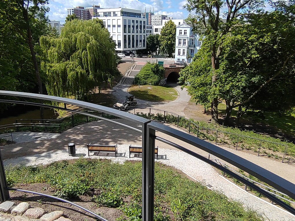 Dreiwallbastion mit historischen Steinmauern und einem Weg, umgeben von Bäumen und Grünflächen