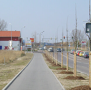 Blick auf einen Gehweg mit fahrenden Autos auf der Straße.