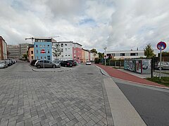 Blick auf eine Abzweigung mit parkenden Autos.