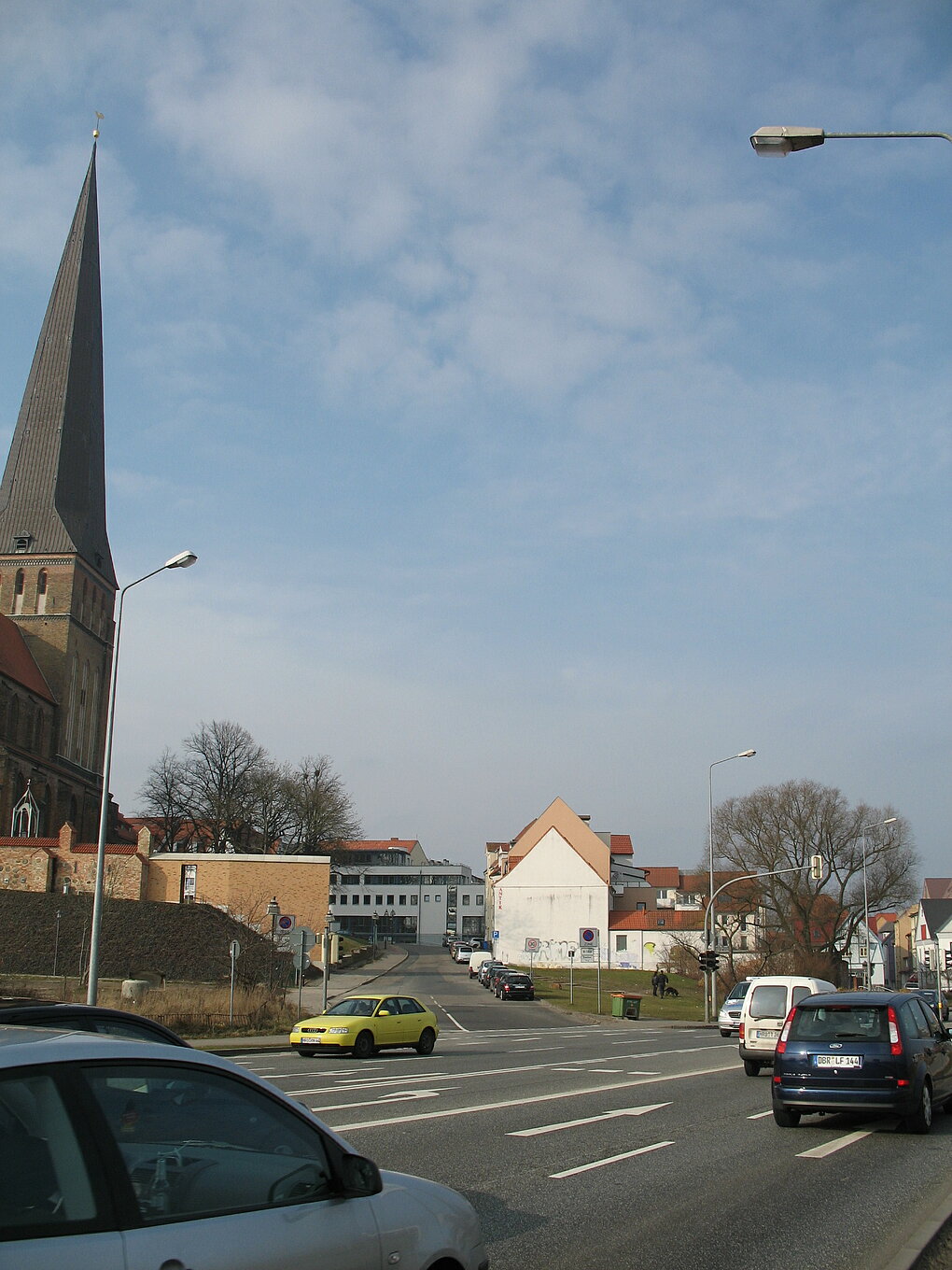 Blick auf eine befahrene Straße mit Petrikirche im Hintergund.