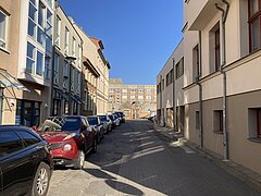 Straße mit parkenden Autos und Gebäuden bei blauen Himmel