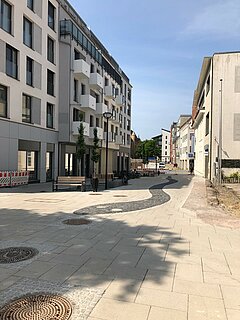 Blcik auf einen leeren gepflasterten Platz.