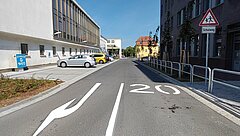 Straße mit Fahrspuren und Richtungspfeilen.