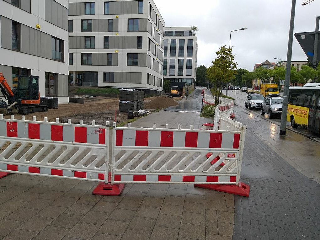 Blick auf einen abgespeerten nassen Gehweg
