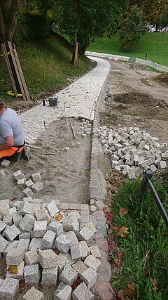 Nahaufnahme von einer Baustelle mit fehlenden Steinen im Weg.