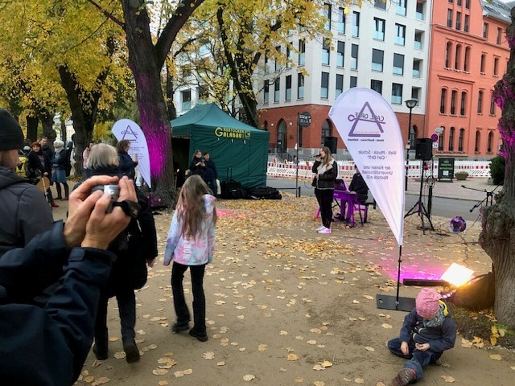 Eine Frau die am Mikrofon singt und Menschen die zuhören.