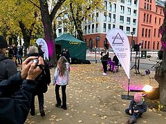 Eine Frau die am Mikrofon singt und Menschen die zuhören.