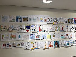 Viele bunte kleine Bilder an einer Wand.