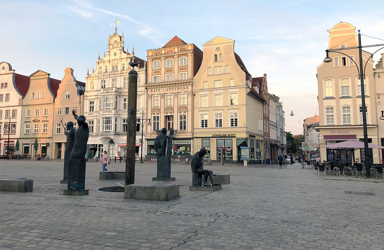 Historische Gebäude mit Giebeln an einem gepflasterten Platz bei Sonnenuntergang