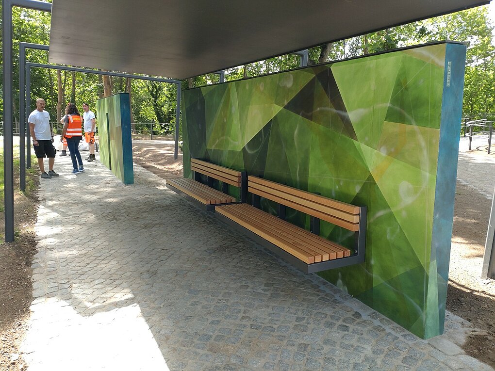 Zwei leere Holzbänke mit Metallgestell.