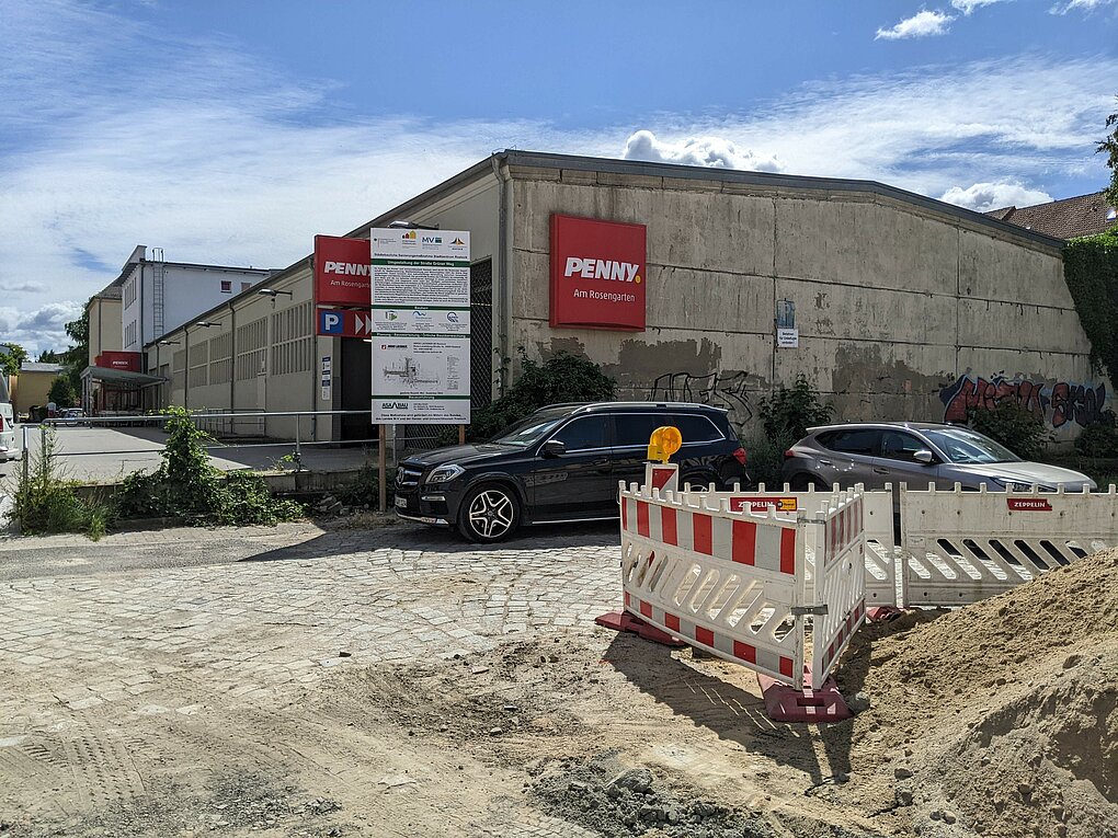 Baustelle mit Baumaterialien vor einem großen Gebäude